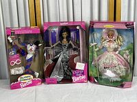 Front view of three Barbie dolls in their boxes: Olympic Gymnast, Charity Ball, and Little Bo Peep Barbie dolls visible with packaging and labels.
