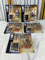 Top view showing all five Mattel NBA Super Stars action figures in original packaging arranged on a surface. Visible packaging wear and creasing on backing cards.