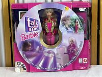 Front view of Talk with Me Barbie in original pink box with window display, showing the doll dressed in bright pink and gold outfit and accessories visible inside packaging.