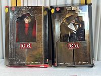 Two Cruella De Vil dolls in original packaging from 101 Dalmatians Great Villains Collection, showing fronts of boxes and visible box aging and damage.