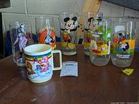 Images of various collector's glasses and mug including McDonald's Captain Crook, Mickey Mouse, Bugs Bunny, Snoopy, and Care Bears.
