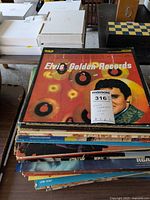 Stack of Elvis Presley vinyl records with 'Elvis Golden Records' visible on top.