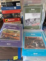 Photo showing several folio format boxed historical war games wrapped in plastic, with titles visible such as Iwo, Acre, Kutuzov, Freeman's Farm, and Marengo.
