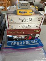 View of the stack of seven games showing titles and box artwork for Legend of the Five Rings, Dominion expansions, The Red Dragon Inn 4, Risk 2210 A.D., and APBA Hockey.