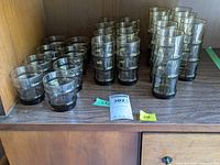 Overview of all smoked glassware showing three groups of glasses with different heights and volumes in a wooden shelf