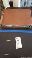 Brown zippered carrying case for Mahjong set, slightly worn.