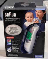 Braun ThermoScan 7 IRT6520CA ear thermometer box showing image of device, baby and mother, key features, and branding.