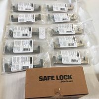 Ten individually packaged satin nickel cabinet handles with mounting hardware and a boxed Safe Lock door knob by Kwikset.