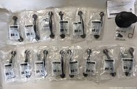 Photo of 14 Liberty cabinet handles in sealed plastic packaging showing bronze/copper 3-inch half round foot pulls.