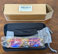 Box with label showing product info, open with glasses in case, cloth, and pouch inside