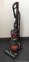 Full front view of upright vacuum showing base, bin and handle
