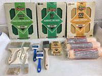 Full set of Gator sandpapers (assorted, 80 grit, 220 grit), assorted paintbrushes, paint scraper, paint roller refills, sponge. Items displayed on flat surface.