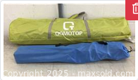 Two carrying bags, green QOMOTOP bag with letters visible, likely the camping tent, and smaller blue bag likely for the chair
