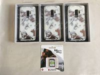 Three Samsung S9 Plus phone cases with white and gold marble pattern in packaging, plus Kingston 64GB memory card in retail packaging.