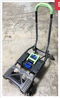 Green and black folding hand truck in upright position showing handle, wheels and platform.