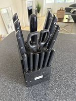 Complete cutting utensil set in black block with knives, scissors, and sharpener visible