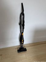 Full view of black upright Eureka vacuum cleaner showing handle, power cord, and vacuum head.