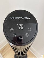 Close-up of the fan's top control panel showing digital temperature display and control icons.