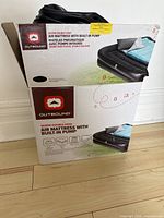 Box of Outbound Queen Double-High Air Mattress with Built-in Pump showing product image and branding.