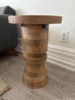 Full side view of the wood side table showing the natural wood grain and the shape and style of the base and top.