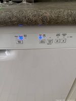Close-up of dishwasher control panel showing cycle selection buttons and illuminated operation indicators.