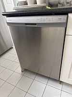 Front view of stainless steel dishwasher installed under counter