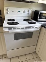 Full frontal view of white Inglis electric stove showing four coil burners on top, oven door with glass window, and white finish.