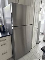 Front three-quarter view showing exterior stainless steel finish and top freezer configuration
