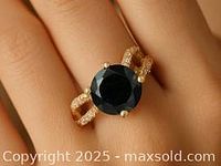 Ring worn on finger showing black diamond center and pavé moissanite band
