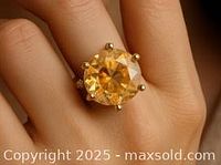 Ring worn on finger showing center orange moissanite stone and fit