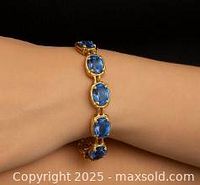 Front view of the bracelet worn on wrist showing natural tanzanite stones and silver links.