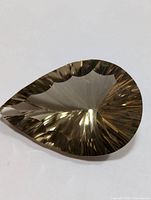 Light brown translucent pear-shaped smokey quartz gemstone with detailed faceting showing both top and bottom views.