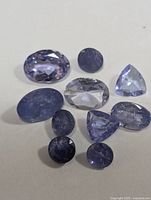 Top view of the 10 tanzanite stones showing color and cut variety.