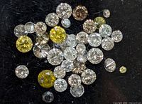 Loose round brilliant diamonds on black background showing mixed yellow, brown and near-colorless stones