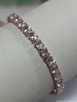 Close-up view of the morganite stones and silver prong setting of the bracelet.