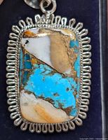 Close-up of the turquoise and silver pendant showing the detailed turquoise stone and decorative silver frame