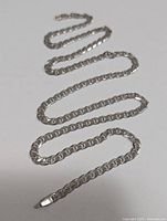 Photo of entire silver chain necklace laid out to show length and form