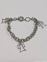 Photo showing the full length of the silver chain bracelet with three angel charms and spring ring clasp.
