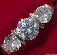 Close-up front view of silver ring with three round cubic zirconia stones.