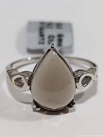 Front view of ring showcasing pear-shaped translucent smokey quartz gemstone with silver band and open loop side details.