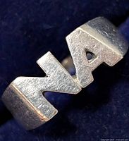 Close-up image of a silver ring showing the letter A on the band
