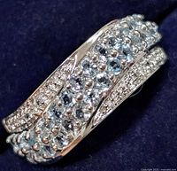 Close-up image of the silver ring with multiple aquamarine stones showing the dominant light blue stones set on a crisscross silver band design.