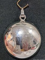 Front view of the round polished silver pendant showing reflective surface and bail with 925 stamp.