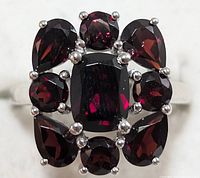 Close-up front view showing garnet stones and silver prong settings on the ring