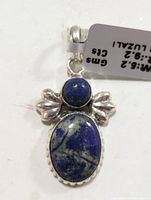 Front view of silver pendant with round and oval Lapis Lazuli stones and decorative silver details.
