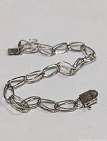 Silver chain link bracelet laid out showing the full length and clasp.