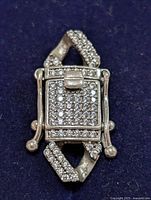 Front view of the rectangular silver bracelet lock with clear cubic zirconia stones densely set on its surface against a dark background.