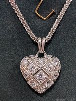 Close-up front view of the silver heart pendant with cubic zirconia stones on a silver chain.