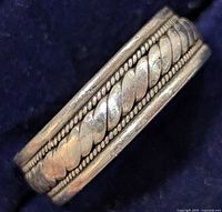 Close-up of the ring showing braided design and beaded edges