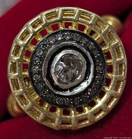 Close-up front view of the silver ring highlighting the central rough-cut diamond surrounded by smaller diamonds and the ornate lattice bezel.